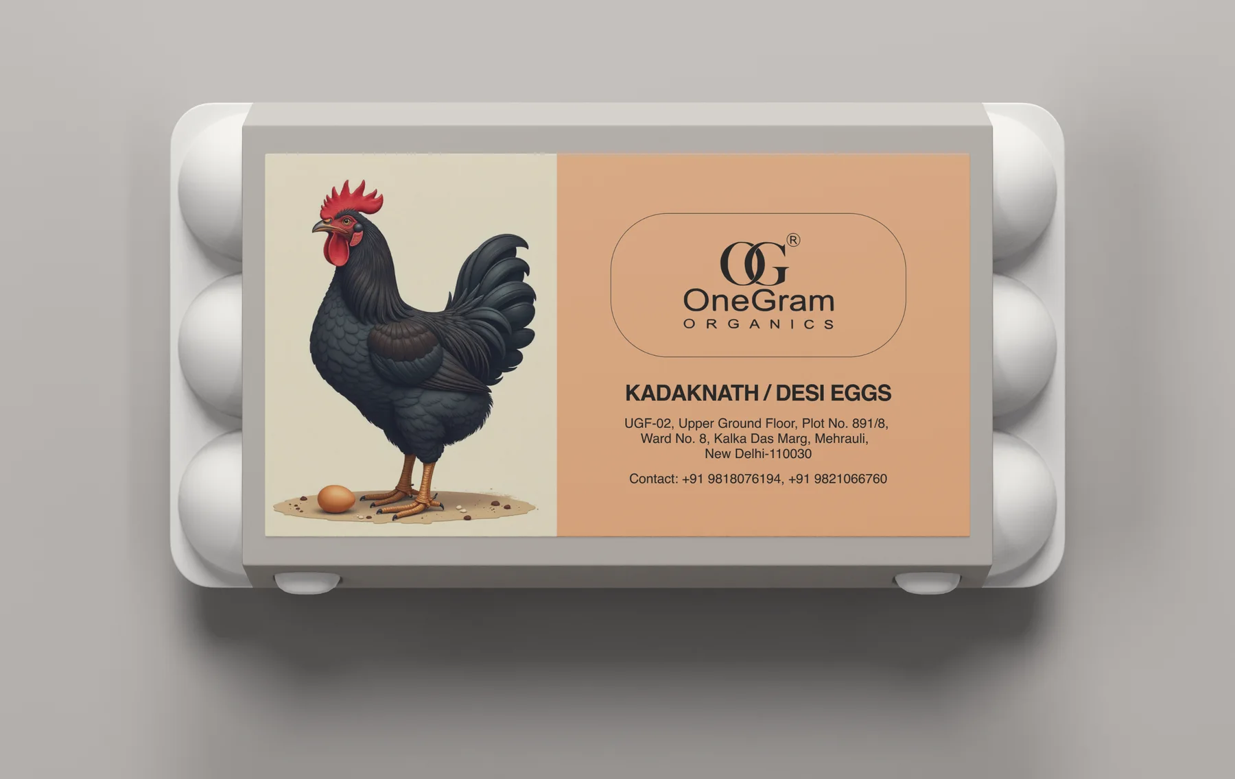 The egg carton: a moulded white six-egg tray with the label wrapped across the front, the black Kadaknath bird on cream at the left and the OneGram Organics mark on peach at the right.