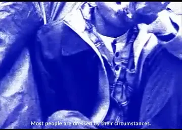 The manifesto film: footage of men dressing and waiting, pushed into a single hard blue, with lines of the manifesto typed along the bottom of the frame.