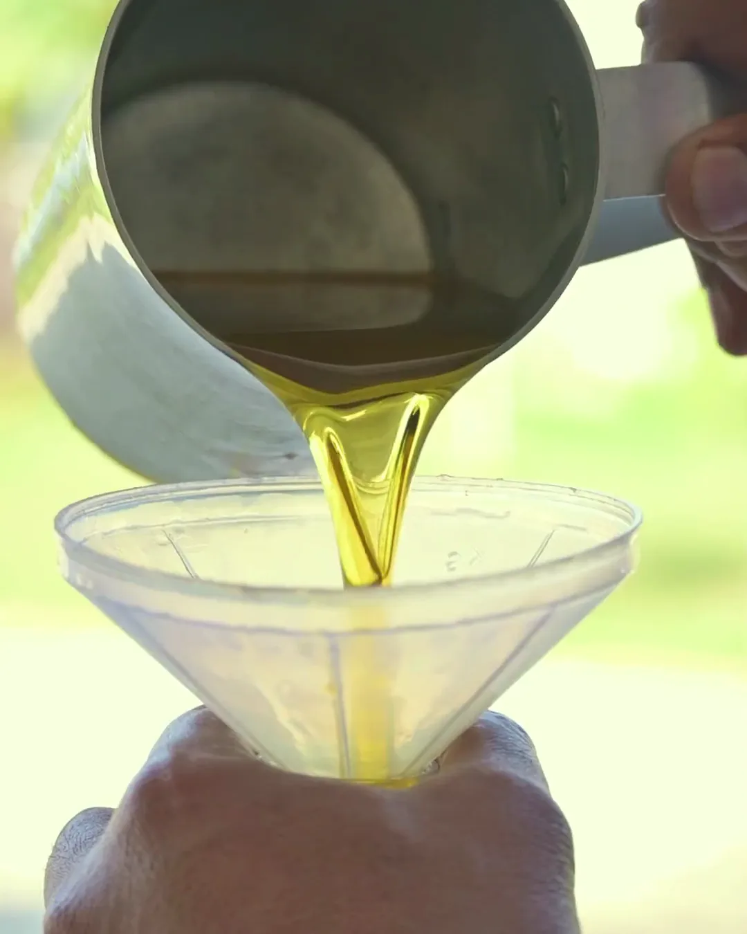 The highlight film: cold-pressed oil poured into a bottle, dried red chillies tipped into a bowl, turmeric falling in a stream, and a row of filled bottles.